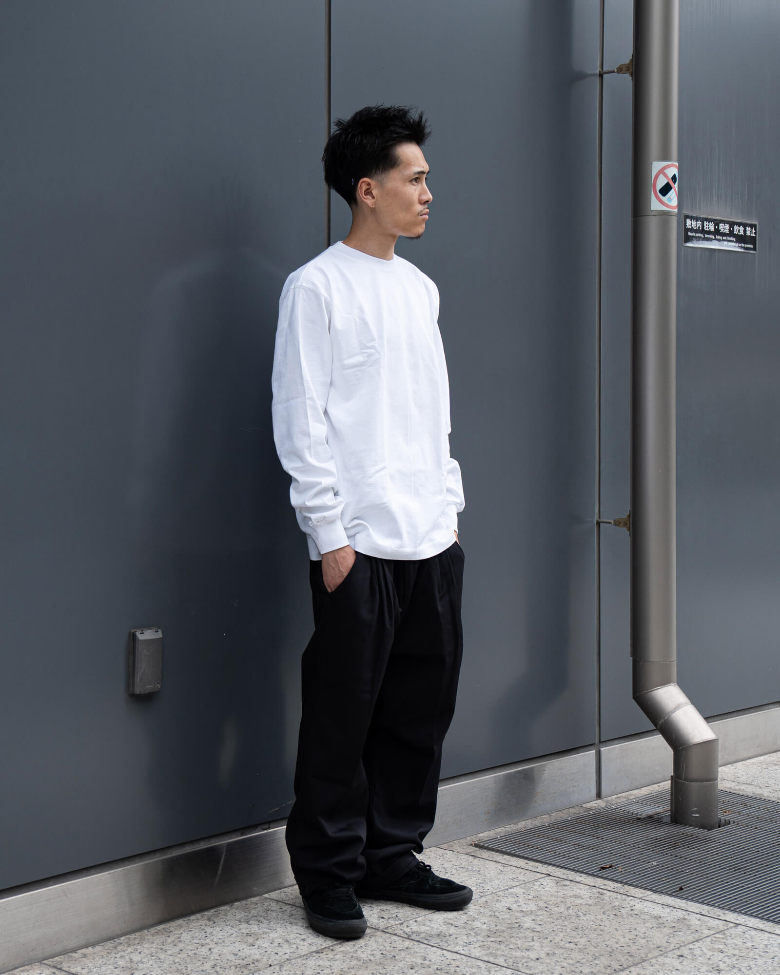 キャンバーのホワイト長袖Tシャツにレッドキャップの黒スラックスを合わせたスタッフコーデ