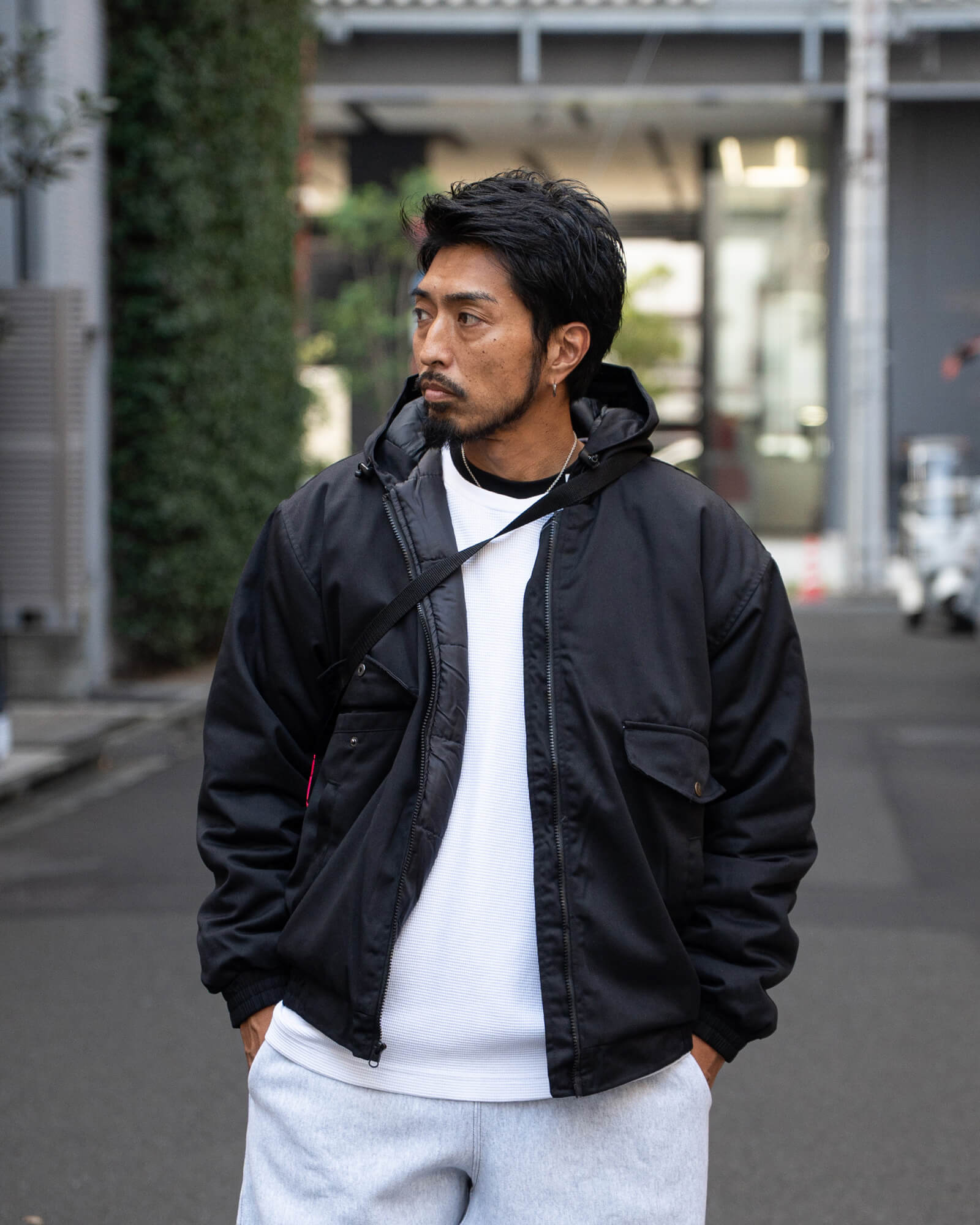 ブラックのフードジャケットに白のサーマルを合わせたレイヤード