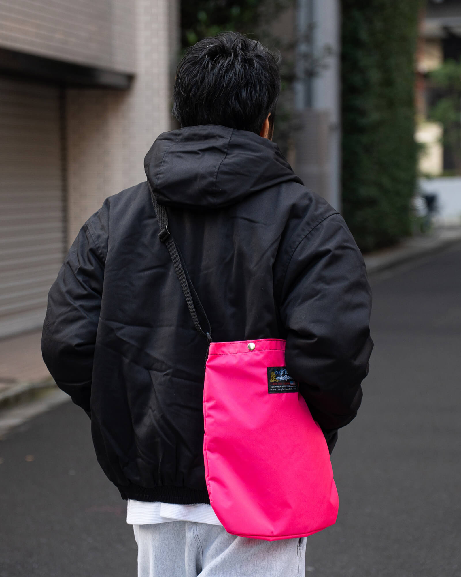 ブラックのフードジャケットとホットピンクのトートのバックスタイル