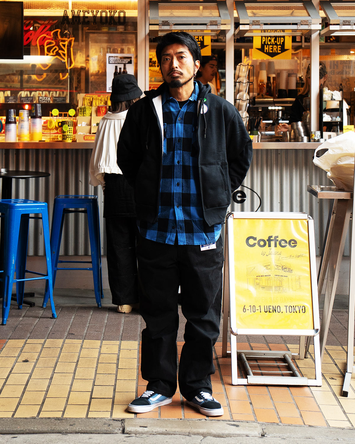 黒のジップパーカーの下にブルー×ブラックのBIGBILL 121を重ね、黒のカーペンタージーンズを合わせた正面の全身